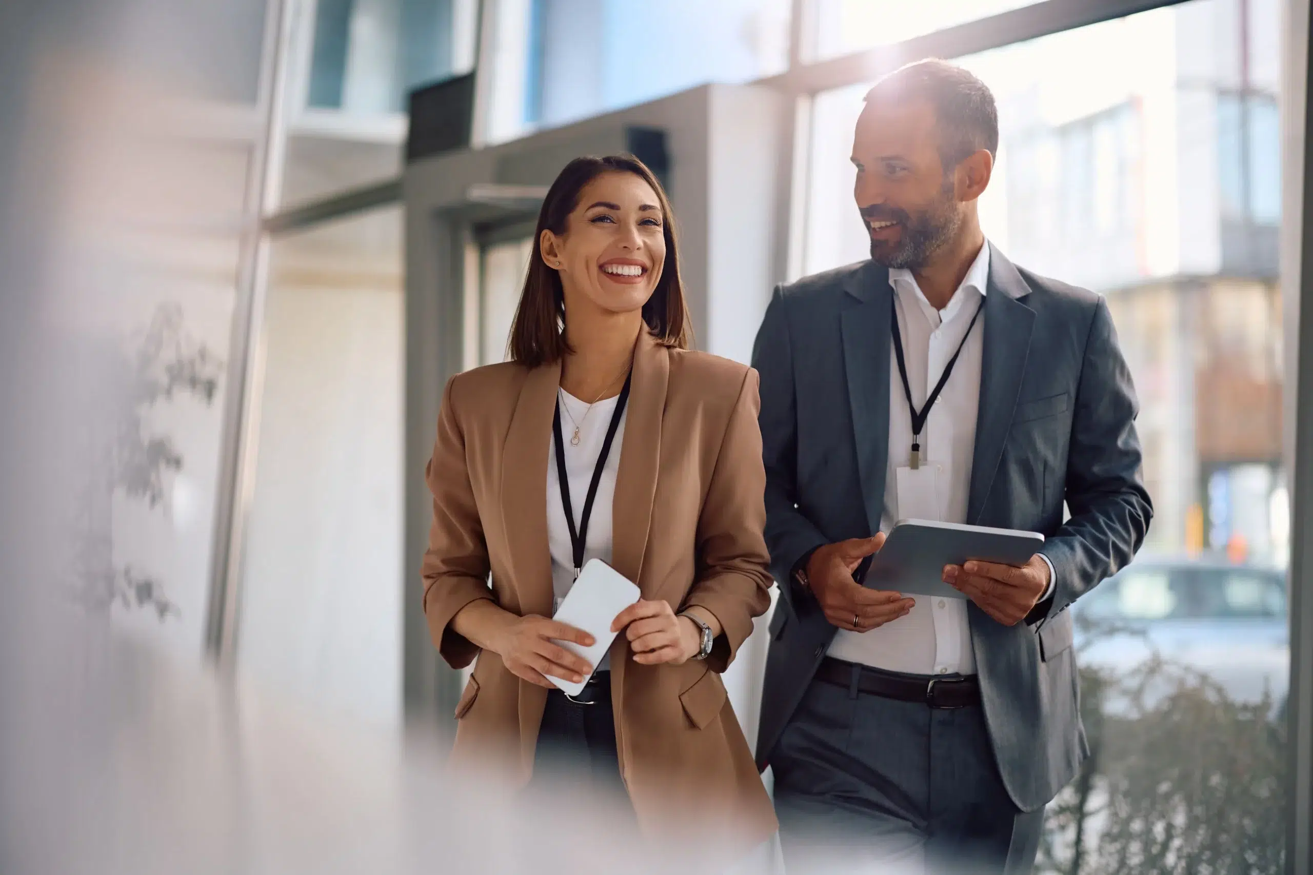Zwei Personen im Anzug gehen durch ein Büro, repräsentieren den Coaching-Prozess für Nachfolger in Familienunternehmen.